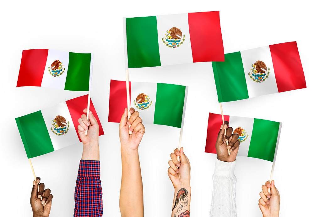 Hands holding Mexican flags